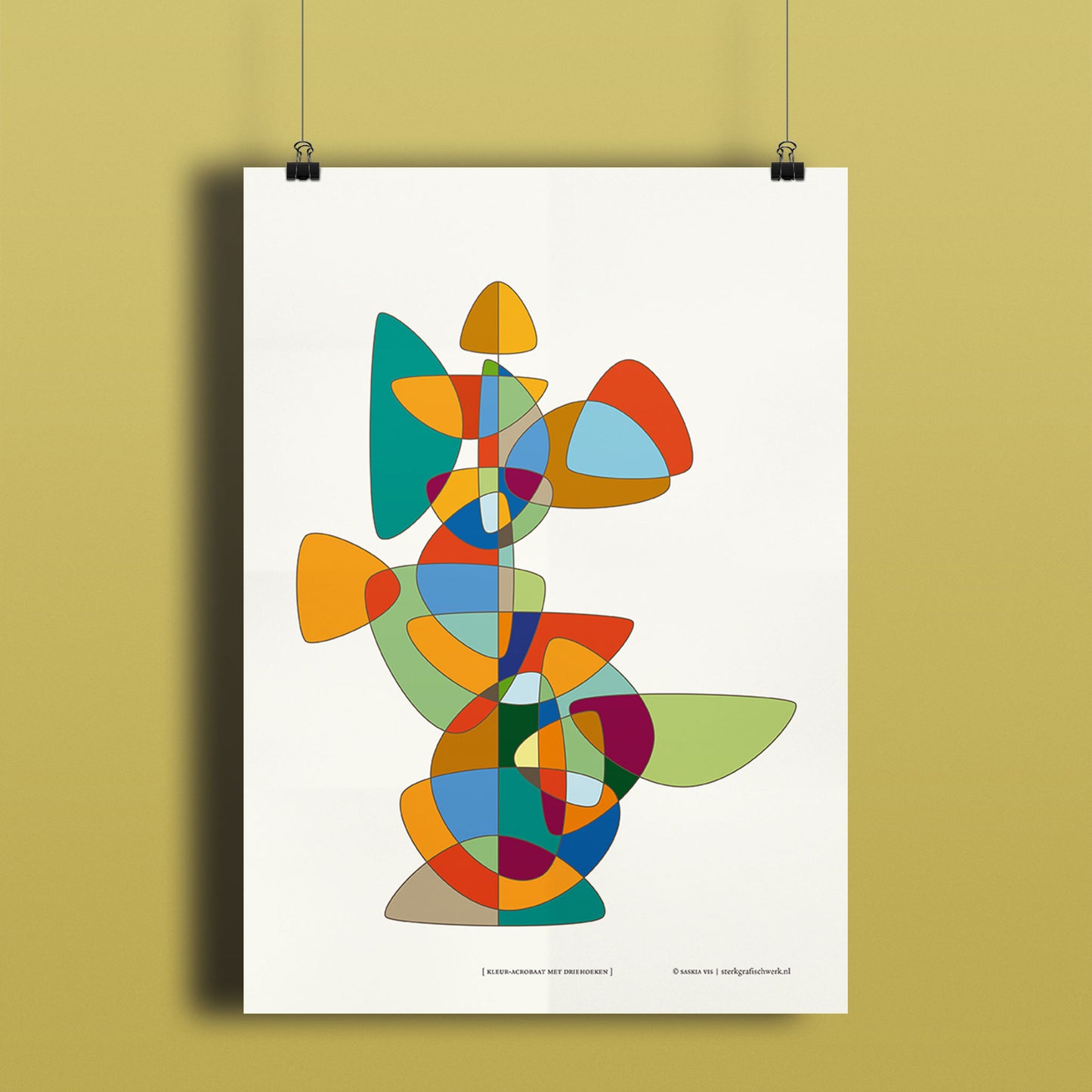Productafbeelding, poster "kleur-acrobaat met driehoeken", hangend aan een okergeel gekleurde wand, een overzichtsfoto
