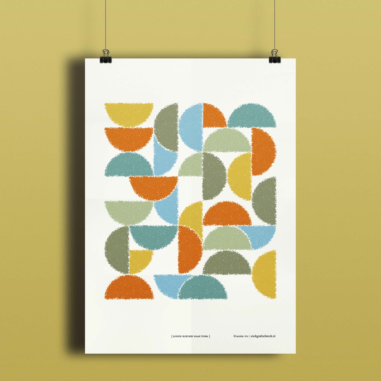 Productafbeelding, poster "ronde kleuren naar terra", hangend aan een okergeel gekleurde wand, een overzichtsfoto