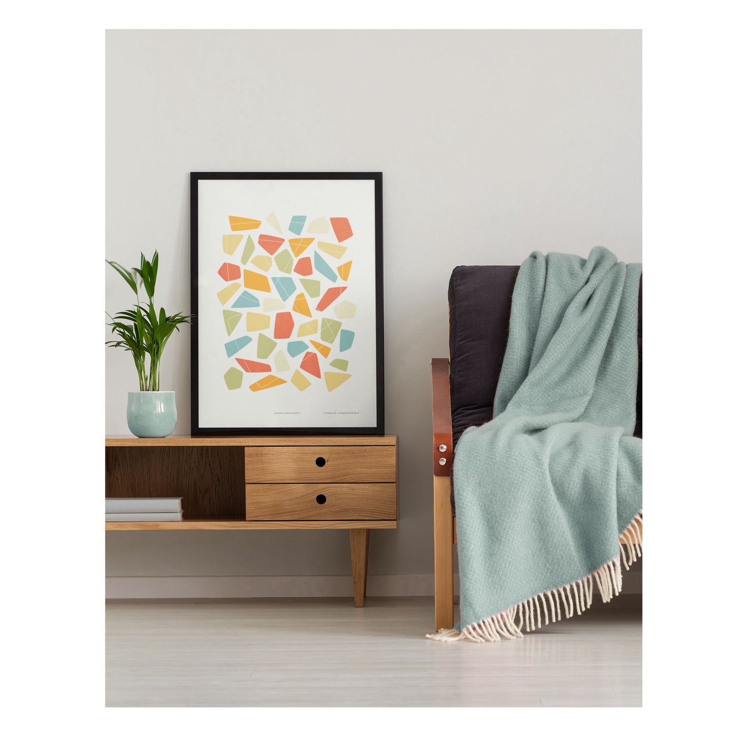 Productafbeelding, poster "zachte zomer-stenen", foto impressie 2, staande op een tafel naast een bank in een interieur
