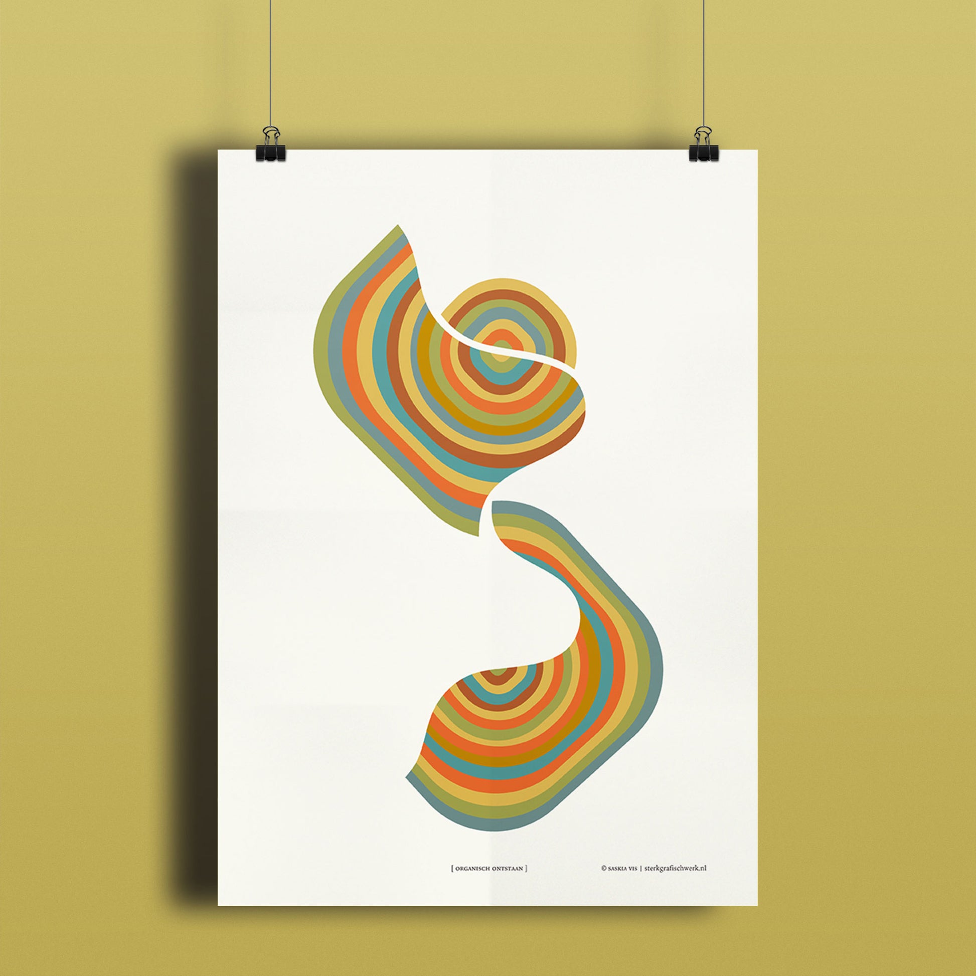 Productafbeelding, poster "organisch ontstaan", hangend aan een okergeel gekleurde wand, een overzichtsfoto