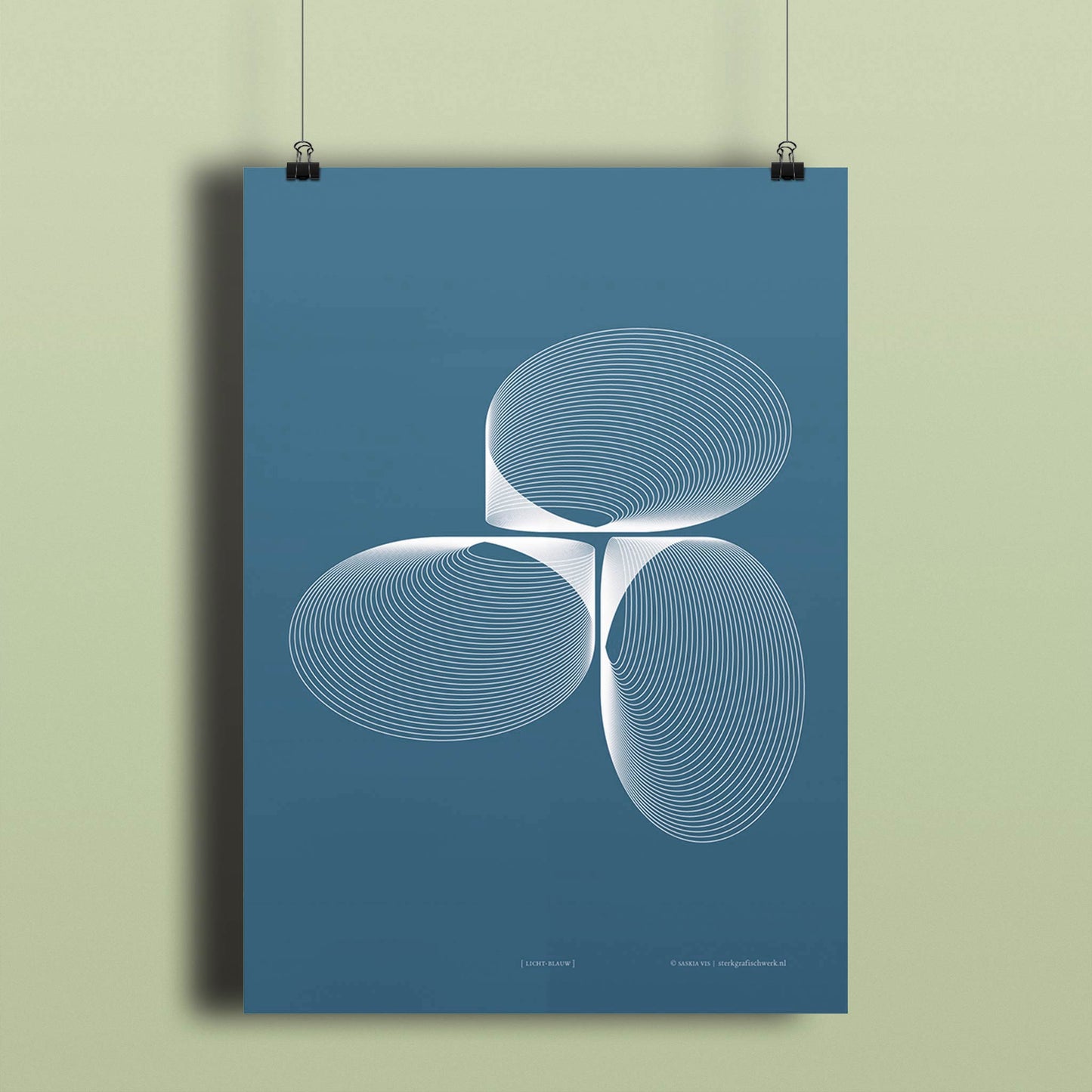 Productafbeelding, poster "licht-blauw", hangend aan een lichtgroen gekleurde wand, een overzichtsfoto