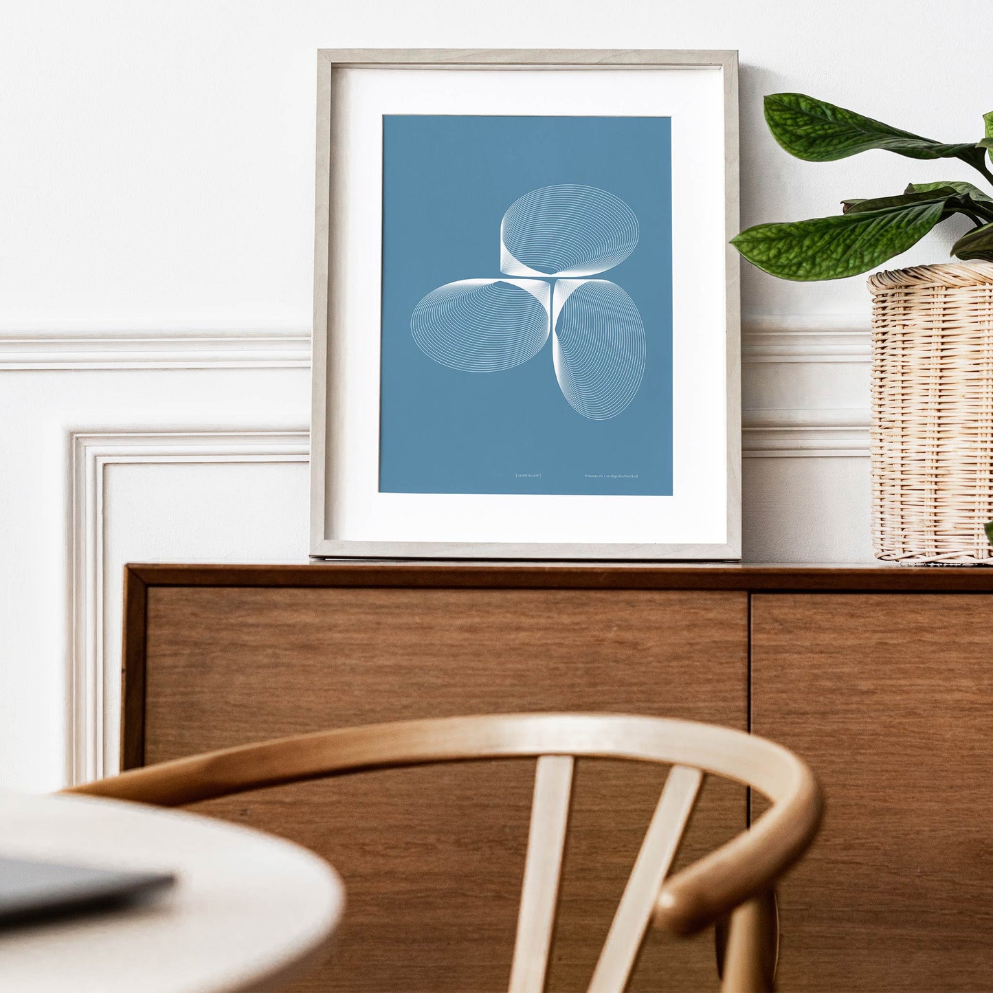 Productafbeelding, poster "licht-blauw", foto impressie 3, ingelijst staande in een interieur op een kast