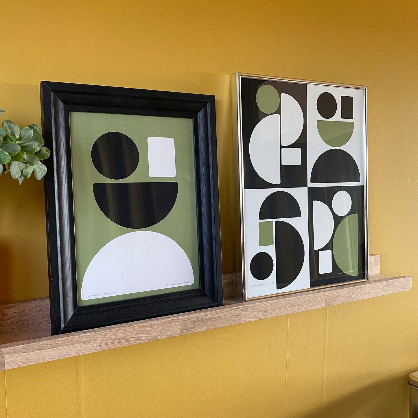 Productafbeelding, poster "alle sommen + twee kleuren", samen met een andere poster ter impressie op een fotoplank