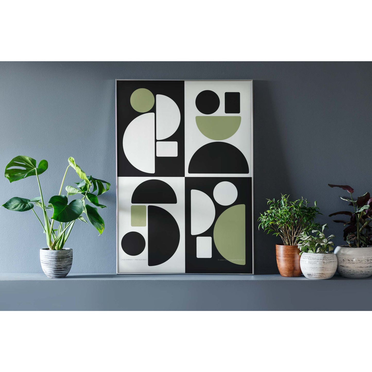 Productafbeelding, poster "alle sommen + twee kleuren", foto impressie 3, staande in een interieur met wat decoratie