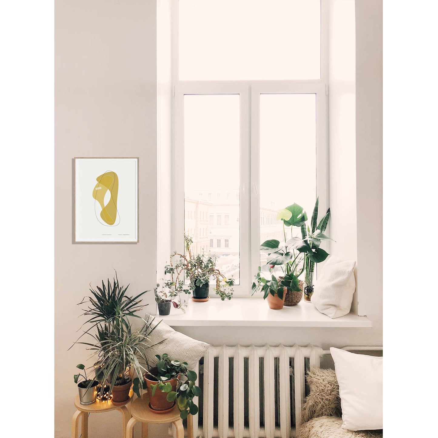 Productafbeelding, poster "vorm één in ocre jaune", foto impressie 2, hangend ingelijst in een interieur naast een raam met planten