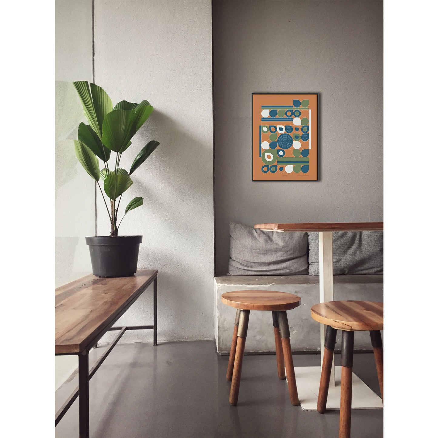 Productafbeelding poster "jardin jaune" impressie foto ingelijst, hangend boven een tafel aan een wand in een interieur met plant en krukjes