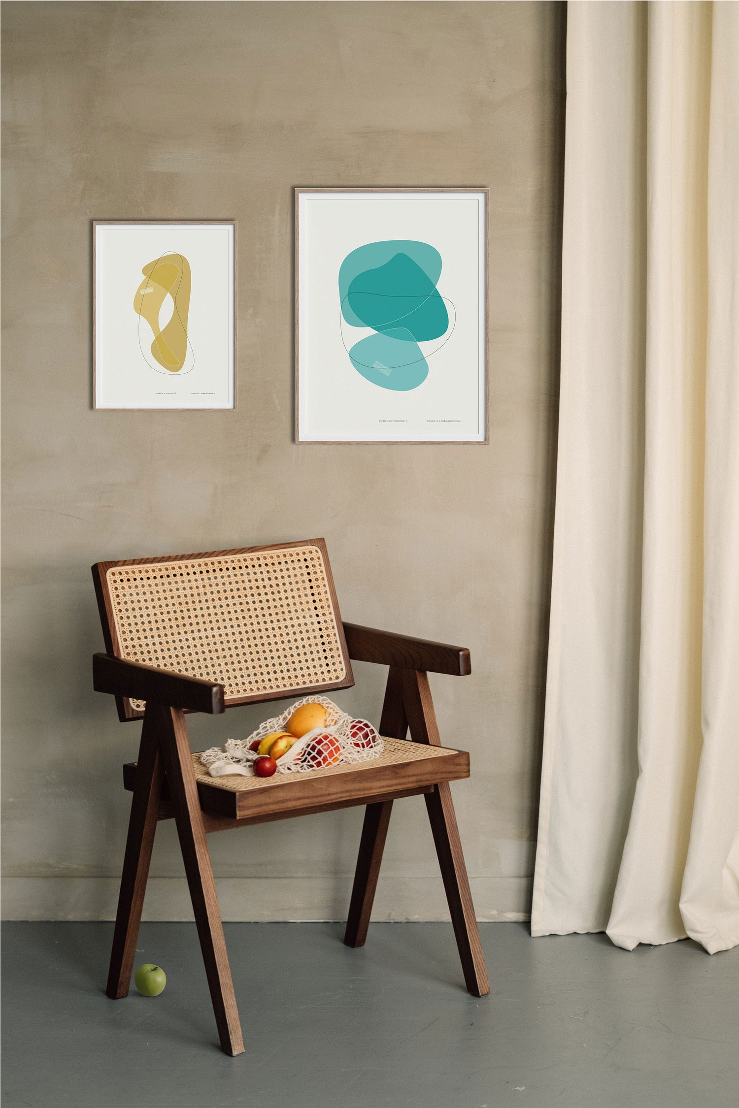 Poster "Vorm één in ocre jaune" en "Vorm zes in turquoise" hangend aan een wand met daaronder een mooie houten stoel
