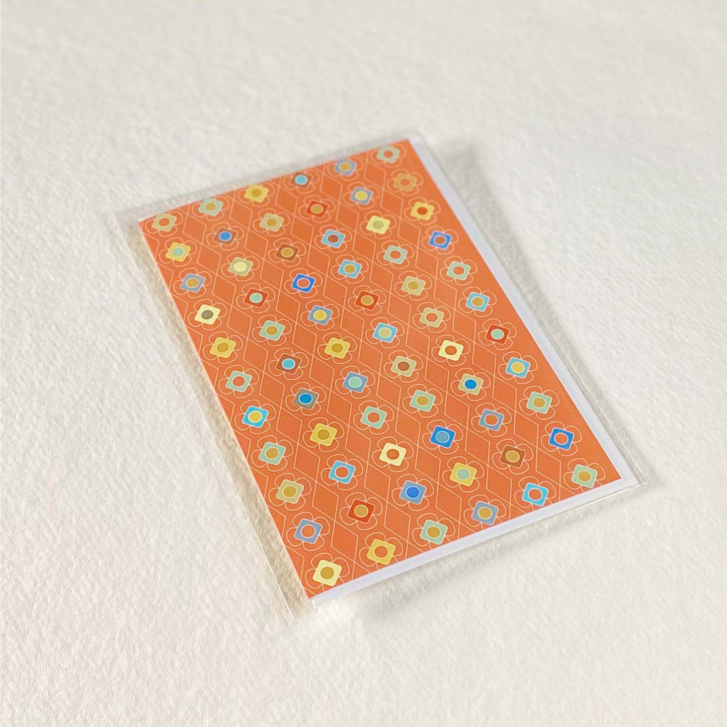 Productafbeelding, foto wenskaart "kleur carrousel oranje" in zijn verpakking liggend op een achtergrond