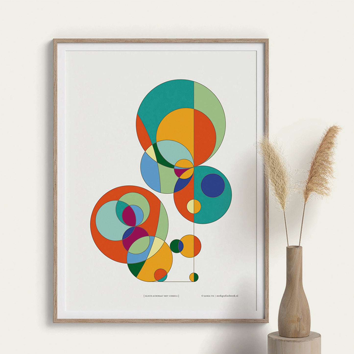 Productafbeelding poster "kleur-acrobaat met cirkels" ingelijst hangend aan een creme gekleurde wand, een overzicht foto