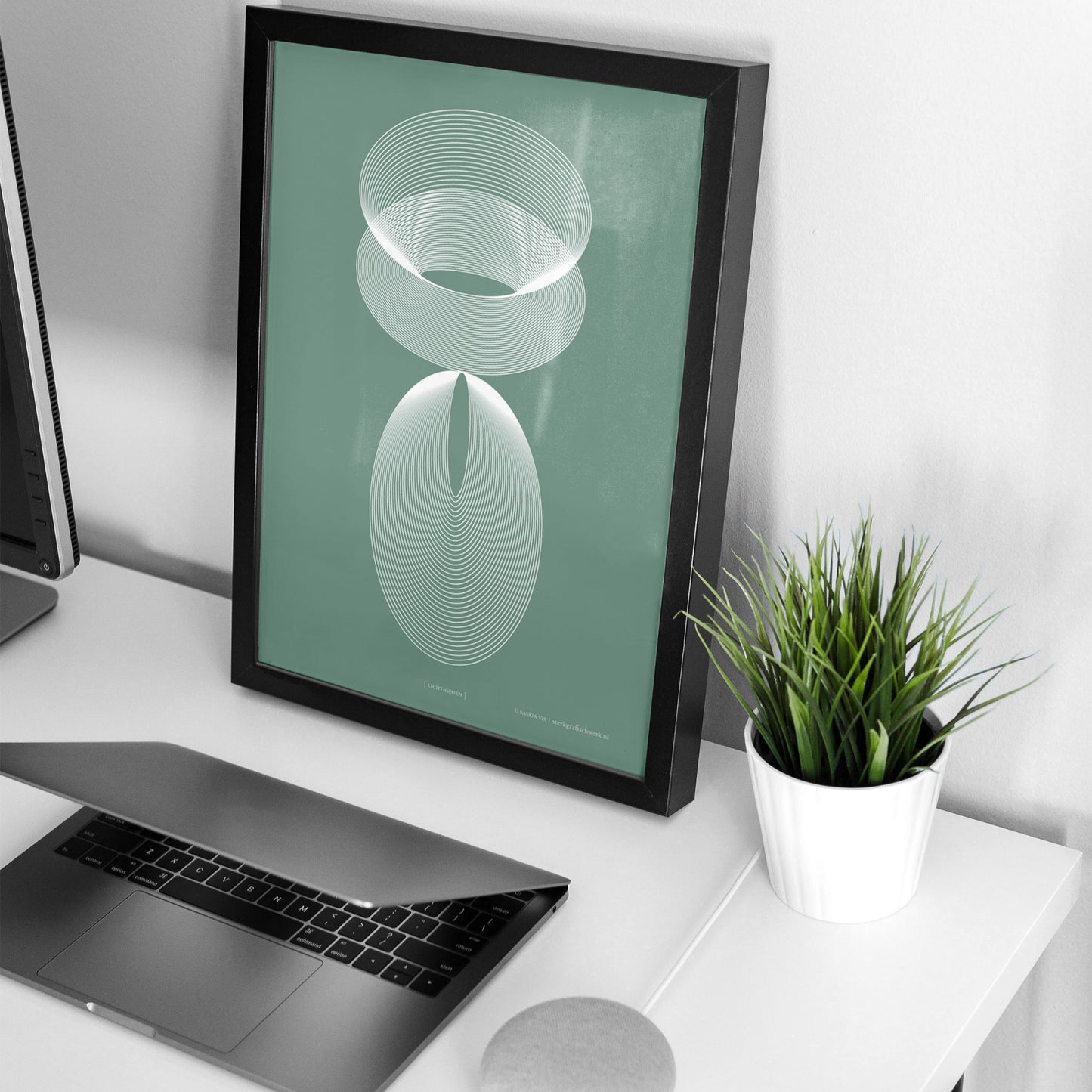 Productafbeelding poster "licht-groen" 4de impressie ingelijst staande op een bureau in een interieur